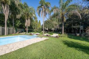 a swimming pool in a yard with palm trees at Casa Campo Hotel Boutique - San Pedro in San Pedro