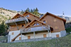 a large wooden house with two decks on a hill at LesChalets de Pré Genty in Oz +16 photos