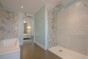 ein Badezimmer mit ebenerdiger Dusche und Badewanne in der Unterkunft Hotel Heritage in Cognac + 30 Fotos