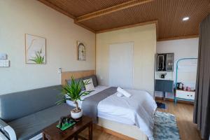 a bedroom with a bed and a couch at Home Đăng Hải in Phú Hiệp