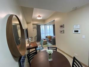 a living room with a table and a mirror at Paladium Iloilo Smart Home Condo in Iloilo City