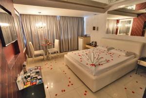 a bedroom with a large bed with red flowers on it at Altana Motel in Brasília