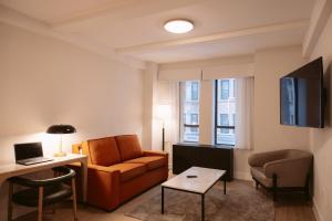 a living room with a couch and a table at Aura Hotel Times Square in New York