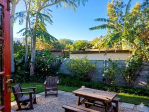 a backyard with a wooden picnic table and chairs at Route 62 B&B in Robertson