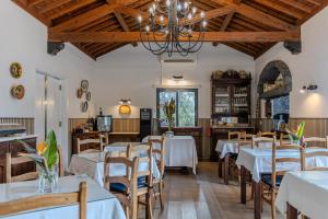 a dining room with white tables and chairs at Quinta De Santana in Rabo de Peixe