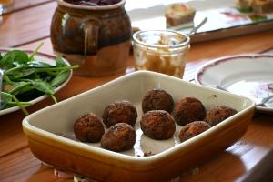 a bowl filled with meatballs on a wooden table at Cottage des Moutons Espiègles in Saint-Martin-de-Nigelles