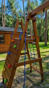 a wooden play structure with a climbing ladder at Sosnowe Tarasy in Boszkowo-Letnisko