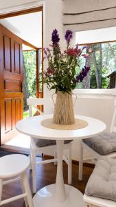 a white table with a vase with purple flowers on it at Sosnowe Tarasy in Boszkowo-Letnisko