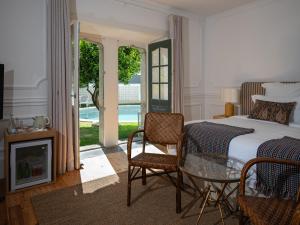 a bedroom with a bed and a table and chairs at Villa Vasco da Gama in Cascais +86 photos