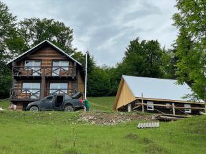 a truck parked in front of a log house at Погарь Квасівський in Kvasy