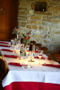 a long table with wine glasses and a stone wall at Le chalet des Etoiles in Lavans-Vuillafans