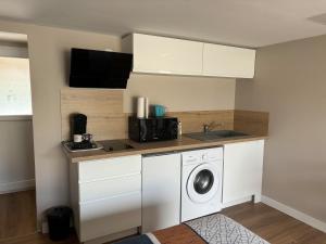 a kitchen with a washing machine and a sink at Studio piscine in Puy-Guillaume