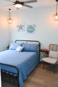 a bedroom with a blue bed and a chair at 2BR Cozy Cottage Private Dock in Davis