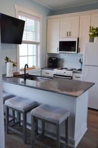 a kitchen with a counter with stools and a sink at 2BR Cozy Cottage Private Dock in Davis +7 photos