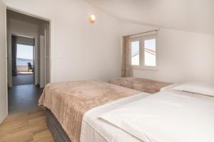 a bedroom with two beds and a view of the ocean at Apartments Vini in Donji Seget