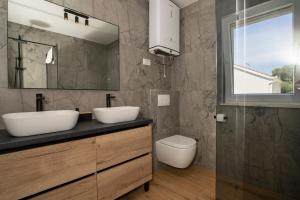 a bathroom with two sinks and a toilet at Apartments Vini in Donji Seget +65 photos
