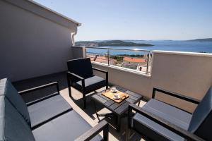 a balcony with a table and a chair and a balcony with the ocean at Apartments Vini in Donji Seget