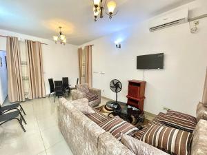 a living room with couches and a flat screen tv at Résidence T&M ODZA Yaoundé Cameroun in Méhandan