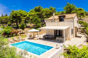 an external view of a villa with a swimming pool at Villa Boscheto Tria in Agios Leon