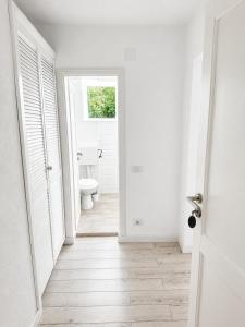 a white bathroom with a toilet and a window at Terasa Baniei in Bucovăţ +4 photos