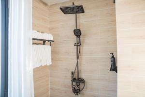 a shower in a bathroom with wooden walls at Alphan Hotel in Vạn Ninh +41 photos