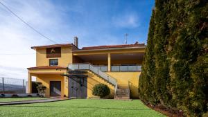 a yellow house with a lawn in front of it at AL Hirondelle in Sernancelhe
