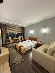 a bedroom with two beds and a living room at Hotel Kocibelli POOL & SPA in Korçë
