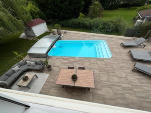 an overhead view of a swimming pool with chairs and a table at Studio piscine in Puy-Guillaume +4 photos