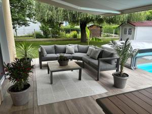 a patio with a couch and a table and plants at Studio piscine in Puy-Guillaume