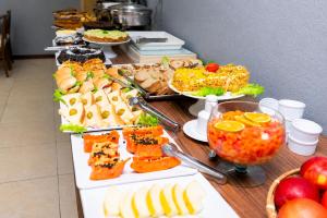 a buffet with many different types of food on a table at HANNA Búzios Al Mare Hotel in Búzios
