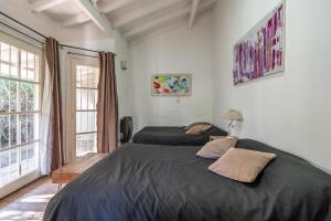 a bedroom with two beds and two windows at Casa Campo Hotel Boutique - San Pedro in San Pedro