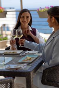 two women sitting at a table with glasses of wine at Radisson Blu Resort, Malta St. Julian's in St. Julianʼs +109 photos
