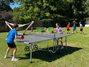 a group of children playing ping pong on a ping pong table at Leśna in Ostróda
