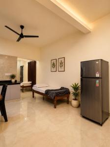 a living room with a bed and a refrigerator at Pinto Eden Home Stay 5 Star Luxury Stay in Chikmagalur in Sangameswarpet