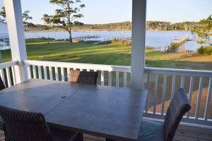 a table on a porch with a view of the water at Waterfront Home 3BR King bed Private Dock in Smyrna