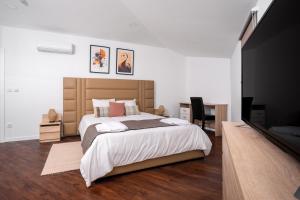 a bedroom with a large bed and a desk at AL Hirondelle in Sernancelhe