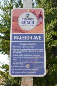 a sign on a pole that saysatlantic beach with a relishagency at Steps to Beach 2BR 2BA duplex in Atlantic Beach