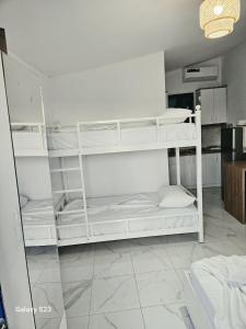 a room with white bunk beds in a kitchen at Cozy Family Studio 2 in Ksamil