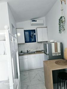 a kitchen with white cabinets and a stainless steel refrigerator at Cozy Family Studio 2 in Ksamil