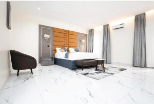 a hotel room with a bed and a chair at Oxvera Hotel Limited in Umuahia
