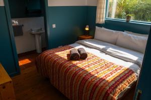 a bedroom with a bed with two slippers on it at The Common Knowledge Centre in Kilfenora