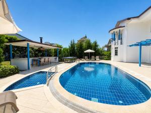 a swimming pool in a yard with a house at Villa Fergana in Oludeniz