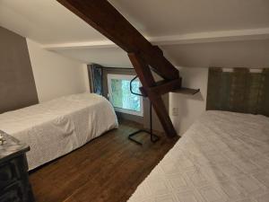 a attic bedroom with two beds and a window at Les Rochers de Bayac in Bayac +20 photos