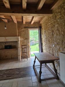 a room with a table and a chair and a window at Les Rochers de Bayac in Bayac
