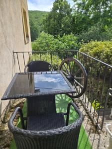 a table and chairs sitting on a balcony at Les Rochers de Bayac in Bayac
