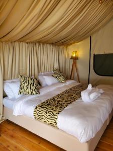 a bed with two stuffed animals on top of it at Camp Ayza Elementaita in Kariandus