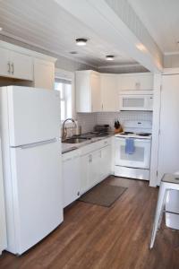 a kitchen with white cabinets and a white refrigerator at Oceanfront Townhouse steps to the Beach in Atlantic Beach