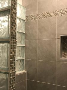 a shower with glass shelves in a bathroom at Oceanfront Townhouse steps to the Beach in Atlantic Beach