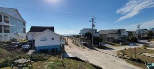 a street in a small town with houses and cars at Oceanfront Townhouse steps to the Beach in Atlantic Beach