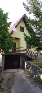a house with a garage in front of it at Kuća za odmor VITICA s vanjskim kaminom in Kupres